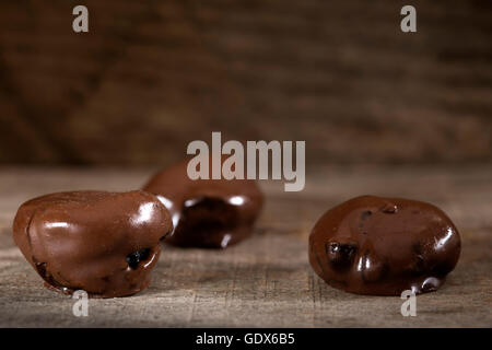 Le prugne di cioccolato sulla rustico sfondo di legno Foto Stock