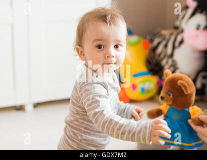 Baby boy gioca con il giocattolo nella sua stanza. Foto Stock