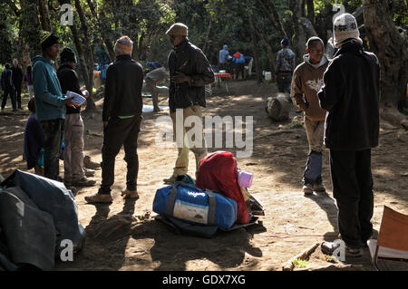 Persone rilassante la mattina al grande albero Camp (o Mti Mkubwa / Forest Camp), il Monte Kilimanjaro National Park, Tanzania Foto Stock