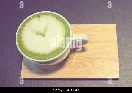 Tazza di latte art caffè su legno, tè verde latte, vintage Foto Stock