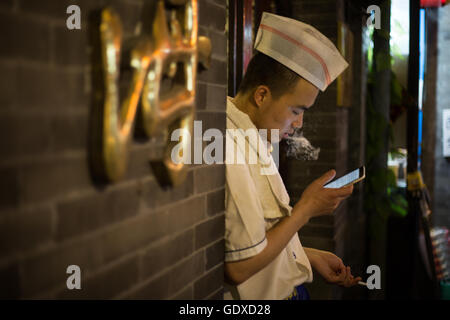 I giovani cinesi giocare con i loro smartphone e social media, a Pechino, Cina Foto Stock