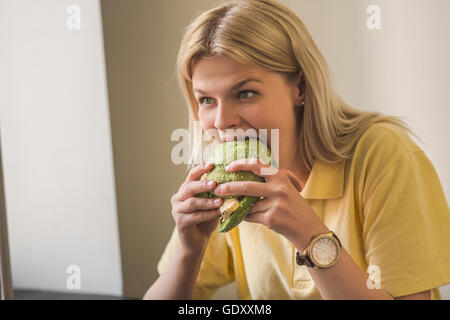 Donna di mangiare vegan burger in ristorante Foto Stock