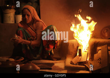 Una donna che fa il pane di grano o rotis su un caminetto, Rajasthan, India Foto Stock