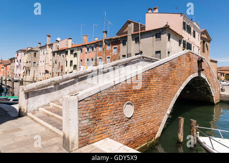 Tipico ponte attraverso un canale di Chioggia, Laguna Veneziana, Italia. Foto Stock