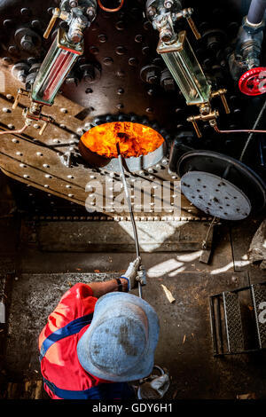 Un lavoro duro per i vigili del fuoco di mettere un altro log in caldaia dell'industria PS battello a vapore sul Fiume Murray in Australia. Foto Stock