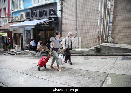 Persone su una strada commerciale del distretto di Kowloon, Hong Kong, Cina Foto Stock