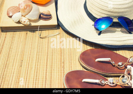 Accessori da spiaggia-occhiali da sole, flip-flop, libro e cappello Foto Stock