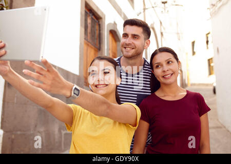 I giovani che viaggiano giovane in vacanza prendendo un selfie con un nuovo amico in una strada stretta mentre vestito in abiti casual Foto Stock