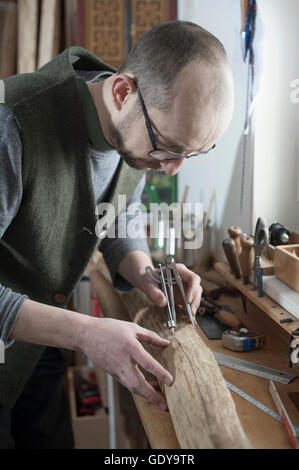 Maschio di bow maker marcatura sul legno con bussola in officina, Baviera, Germania Foto Stock