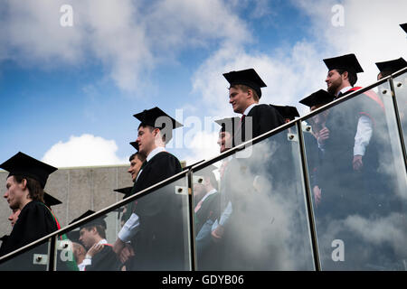 Istruzione superiore nel Regno Unito: un gruppo di Aberystwyth studenti universitari indossando abiti tradizionali, mantelle e schede di mortaio ottenendo pronto per avere il loro gruppo fotografia scattata a loro il giorno di graduazione cerimonia, Luglio 2016 Foto Stock