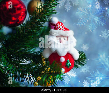 Giocattolo di Natale Santa Claus appeso su albero di Natale artificiale Foto Stock