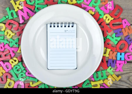 Blocco note sulla piastra bianca Foto Stock