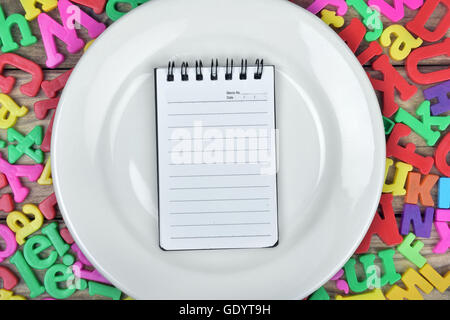Blocco note sulla piastra bianca Foto Stock