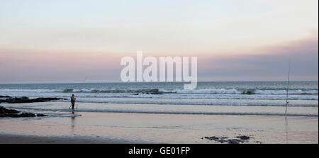 La pesca di pescatori sulla spiaggia durante il tramonto di Viana do Castelo, Regione Norte, Portogallo Foto Stock