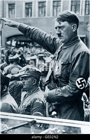 Adolf Hitler in auto aperta indossando la divisa Sturmabteilung e la fascia da braccio swastika che suona il saluto nazista in una sfilata di rally politici in Germania anni '30. Lo Sturmabteilung SA, letteralmente "distacco di tormo") era l'ala paramilitare originaria del Partito nazista (Partito Nazionale Socialista Tedesco dei lavoratori). Ha giocato un ruolo significativo nell'ascesa al potere di Adolf Hitler nel 1920s e nel 1930s. I suoi scopi primari erano quello di proteggere i raduni e le assemblee naziste, interrompendo le riunioni delle parti opposte. Foto Stock