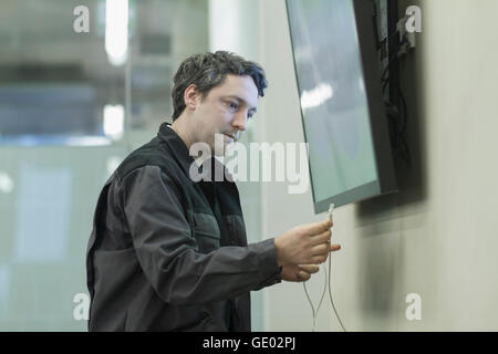 Repairman riparazione di televisione in ufficio, Freiburg im Breisgau, Baden-Württemberg, Germania Foto Stock