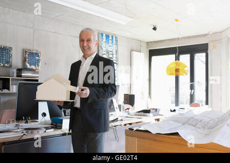 Ritratto di un architetto senior che mostra il modello architettonico e di stare in ufficio, Freiburg im Breisgau, Baden-Württemberg, Germania Foto Stock