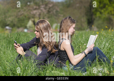 Le ragazze adolescenti seduti nel campo di Freiburg im Breisgau, Baden-Württemberg, Germania Foto Stock