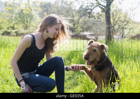 Ragazza seduta nel parco con il suo cane, Freiburg im Breisgau, Baden-Württemberg, Germania Foto Stock