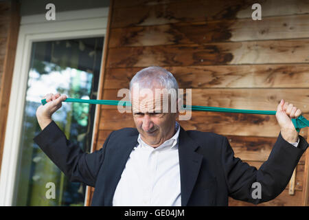 Senior imprenditore tessile di stiramento di Freiburg im Breisgau, Baden-Württemberg, Germania Foto Stock