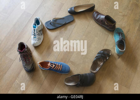 Scarpe in forma di un cerchio sul pavimento in legno Foto Stock