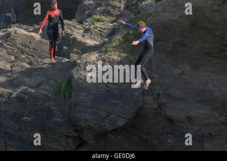 Un adolescente tombstoning off a strapiombo sul promontorio in Newquay, Cornwall. Foto Stock