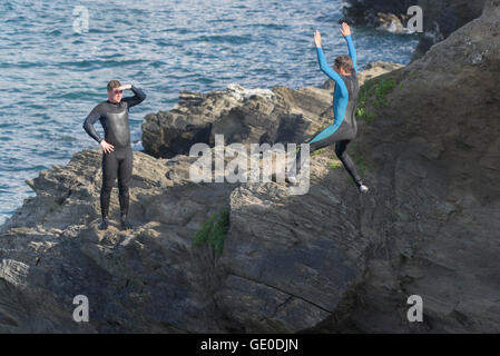 Un adolescente tombstoning off a strapiombo sul promontorio in Newquay, Cornwall. Foto Stock