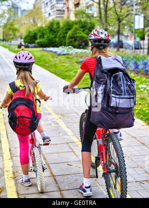 Le ragazze che indossano il casco e zaino ciclyng bicicletta. Foto Stock