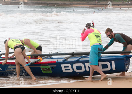 Tradizionale surf boat racing nella serie Ocean Thunder Race a Dee Why Beach, Sydney, australia, mentre il team Bondi si prepara a lanciare surfboat Foto Stock