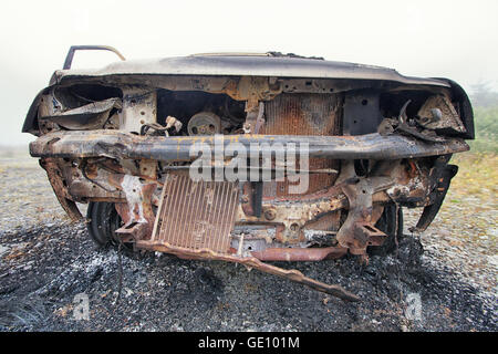 Vista frontale di un bruciata carrello abbandonati su un terreno comune. Foto Stock