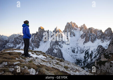 Donna in piedi nelle montagne dolomitiche guardando a vista, Alto Adige, Italia Foto Stock