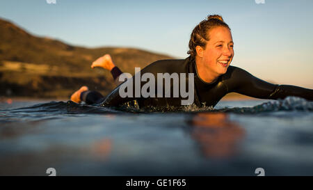 Primo piano di una donna che si addona a surf, Malibu, California, Stati Uniti Foto Stock