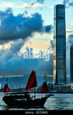 Tradizionale giunca cinese e l'International Commerce Centre, ICC, Kowloon e Victoria Harbour, Hong Kong, Cina. Foto Stock