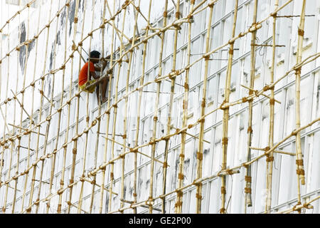 Lavoratore sullo scaffold di bambù. Foto Stock