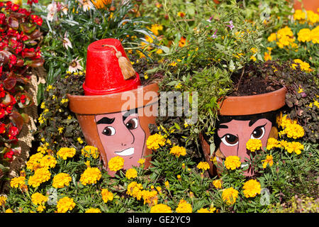 Fiori Pot uomini: Facce dipinte su vasi di piante in un flowerbed ot marigolds. RHS Royal Horticultural Society 2016 Flower Show al Tatton Park Knutsford, Regno Unito Foto Stock