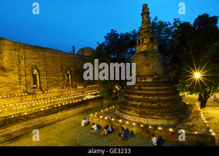 La luce di una candela triple circumambulation attività intorno alla pagoda di Buddha nel tempio di Wat Maheyong Ayutthaya Thailandia Foto Stock