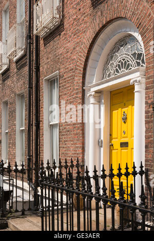 Irlanda, Dublino, Hume Street, verniciato giallo porta con ritaglio di quattro piani in Georgian House Foto Stock
