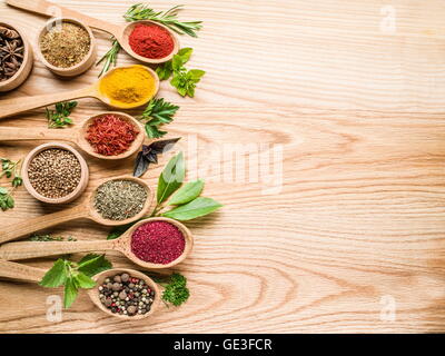 Assortimento di spezie colorate in i cucchiai di legno. Foto Stock
