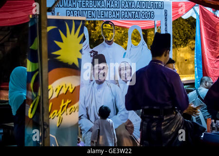 Kuala Lumpur, Malesia. Il 23 giugno, 2016. Un giovane ragazzo avente uno sguardo più da vicino a Anwar Ibrahim poster della famiglia fortunato in giardino, Kuala Lumpur. Credito: Danny Chan/Alamy Live News. Foto Stock