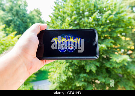 Apple iPhone6 Plus tenuto in una mano che mostra il suo schermo con Pokemon Go. Foto Stock