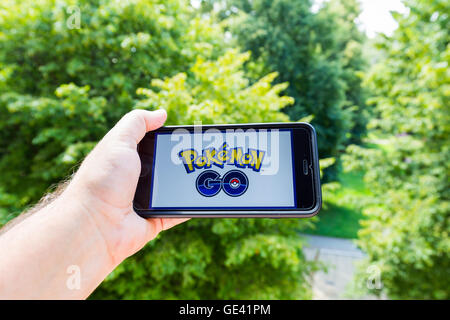 Apple iPhone6 Plus tenuto in una mano che mostra il suo schermo con Pokemon Go. Foto Stock