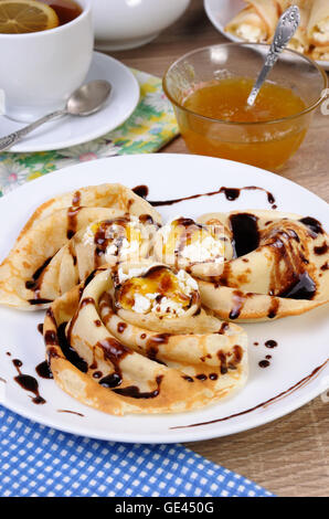 Pancake piegato nella forma di una lumaca per la ricotta con il cioccolato Foto Stock