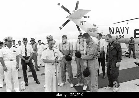 Comandante Philip Eldredge Jerauld (al microfono), nave cappellano dell per il Museo della Portaerei U.S.S. Iwo Jima, offre una preghiera di ringraziamento per il ritorno sicuro dell'Apollo 13 membri di equipaggio poco dopo il loro arrivo a bordo della nave di recupero. In piedi al centro dell'immagine, da sinistra, gli astronauti sono James A. Lovell Jr., Comandante; Fred W. Haise Jr., Modulo Lunare pilota; e John L. Swigert jr. Il pilota del modulo di comando. L'Apollo 13 Modulo di comando "Odissea" schizzato giù a 12:07:44 p.m. (CST), 17 aprile 1970, a concludere in modo sicuro un pericoloso volo spaziale. I tre astronauti sono stati prelevati da un elicottero Foto Stock