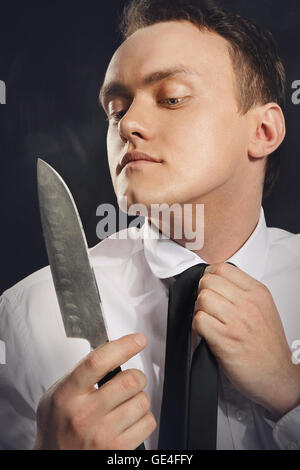Bel Giovane Uomo in camicia bianca navigazione elegante lama cleaver. Foto Stock