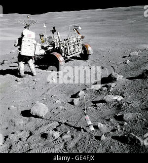 Apollo 16 astronauta Charles M. Duca Jr., pilota del modulo lunare "Orion", sorge nei pressi del Rover, lunare veicolo itinerante (LRV) in corrispondenza della stazione n. 4, vicino a Stone Mountain, durante la seconda Apollo 16 attività extravehicular (EVA-2) al Descartes landing site. I raggi di luce provenienti dal sud del cratere di raggi può essere visto in alto a sinistra. Lo gnomone che è utilizzato come un riferimento fotografico per stabilire verticale locale Sun angolo, scala e colore lunare, è dispiegata nel centro in primo piano. Nota angolarità di rocce in zona. Immagine # : Come16-107-17446 Foto Stock