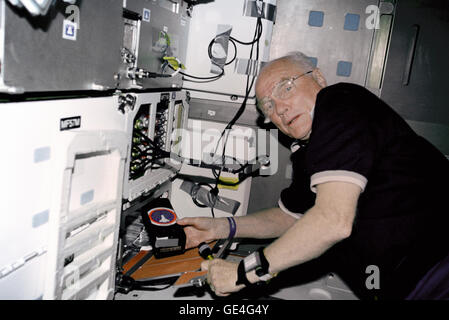 STS-95 payload specialist John Glenn lavora con l'esperimento Osteporosis in orbita (OSTEO) esperimento situato in un armadietto nella scoperta di middeck. Immagine # : STS095-341-003 Data: Novembre 18, 1998 Foto Stock