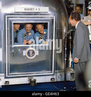 Questa immagine cattura la visita del presidente Richard Nixon all'equipaggio dell'Apollo 11 durante la loro quarantena dopo il loro storico atterraggio sulla luna nel 1969. La fotografia documenta un momento chiave nella storia dello spazio e le conseguenze della missione di successo. Foto Stock