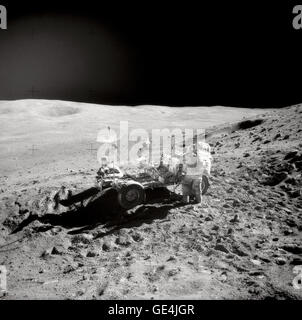Astronauta John W. Young, comandante della missione Apollo 16, sostituisce gli attrezzi in strumento mano portante alla estremità di poppa della "Rover" Lunar veicolo itinerante (LRV) durante la seconda Apollo 16 attività extravehicular (EVA-2) al Descartes landing site. Questa fotografia è stata scattata da astronauta Charles M. Duca Jr., Modulo Lunare pilota. Smokey Mountain, con il burrone grande cratere sul suo fianco, è sullo sfondo a sinistra. Questa vista è guardando a nord-est. Immagine # : Come16-110-17960 Foto Stock