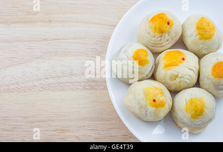 Pasticceria Cinese Mung Bean o Mooncake con tuorlo d'uovo sul piatto e tavolo in legno Foto Stock