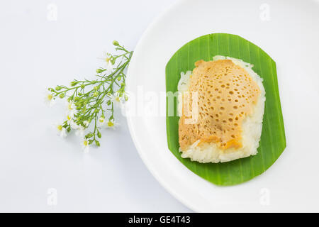 Riso al vapore con crema pasticcera su foglie di banano e piatto con fiore, dolci di riso appiccicoso, Thai dessert, tailandese originale foo Foto Stock